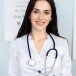 Smiling female doctor with stethoscope in a clinic setting. Warm, professional ambiance.